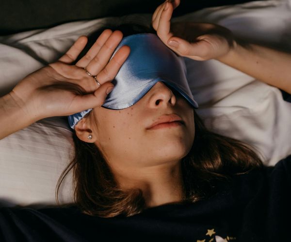 Serene woman meditating with a soft blue light aura around her.